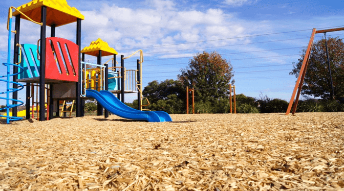 Wood Chip Playground Surface Contained By Pressure Treated Border Timbers In A Community Park Wood Chip Playground Surface Contained By Pressure Treated Border Timbers In A Community Park